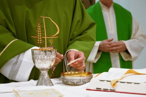a priest is lighting a candle on a table