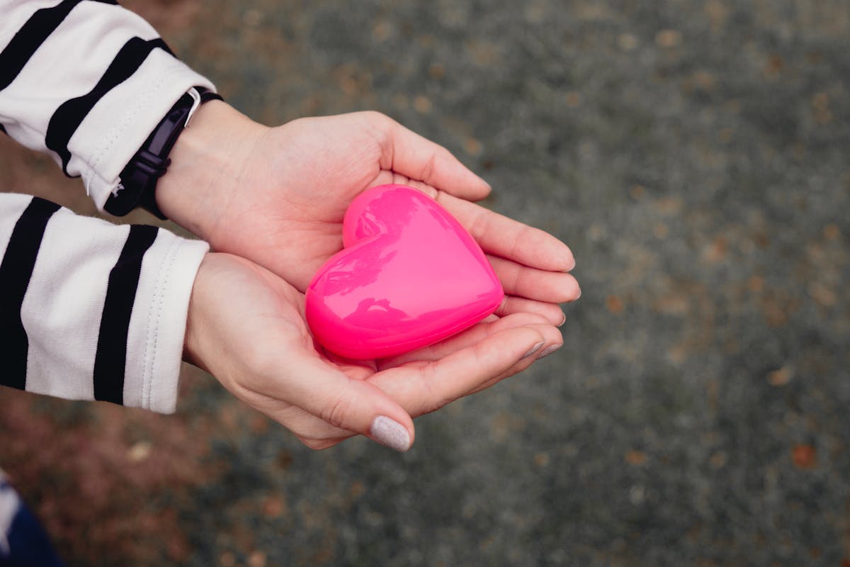 Close Up Shot of a Person Holding a Toy Heart