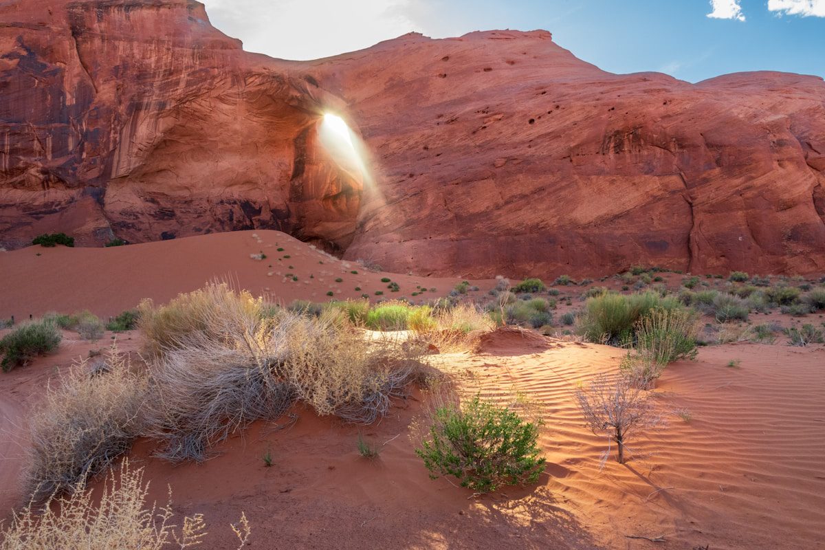 A desert scene with a rock formation in the background