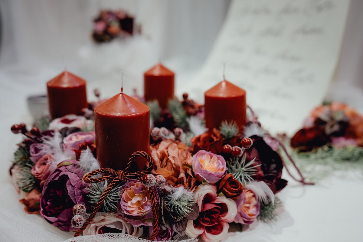 Warm, festive candle wreath adorned with floral decorations, perfect for Christmas table settings.