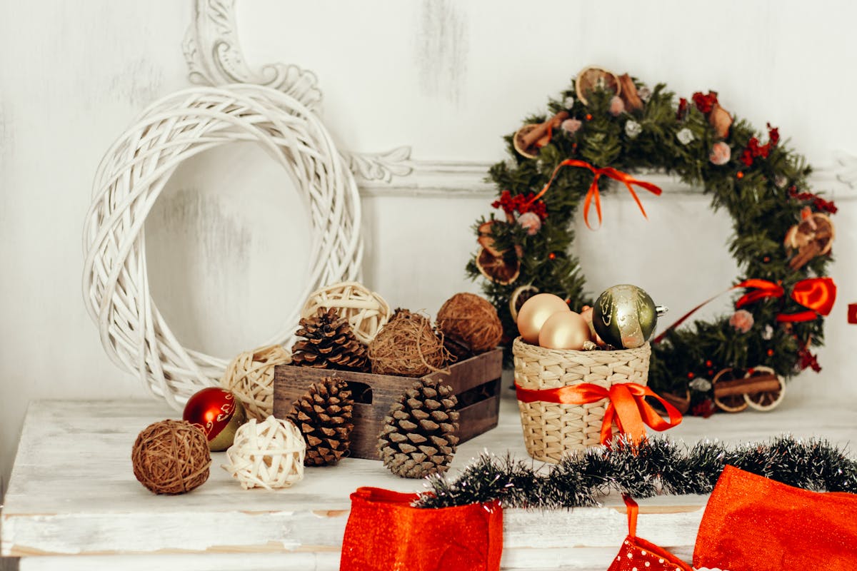 Charming Christmas decor featuring pine cones, ornaments, and a wreath in a cozy indoor setting.
