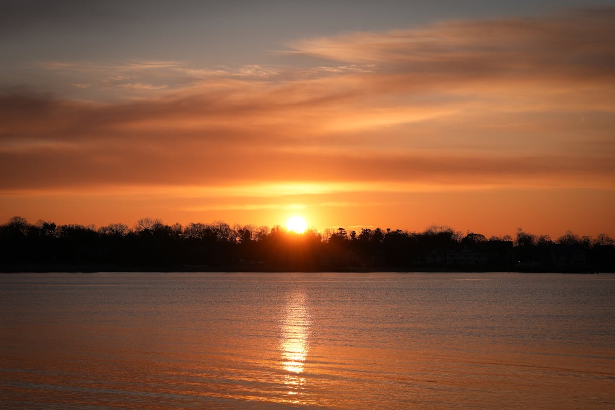 A stunning sunrise over Cove Island Park in Stamford, Connecticut, reflecting vibrant hues on the water.