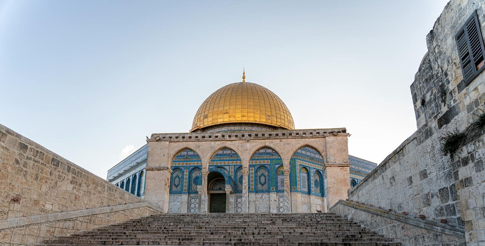 A breathtaking image of the Dome of the Rock's ornate facade and golden dome in Jerusalem, a renowned religious landmark.