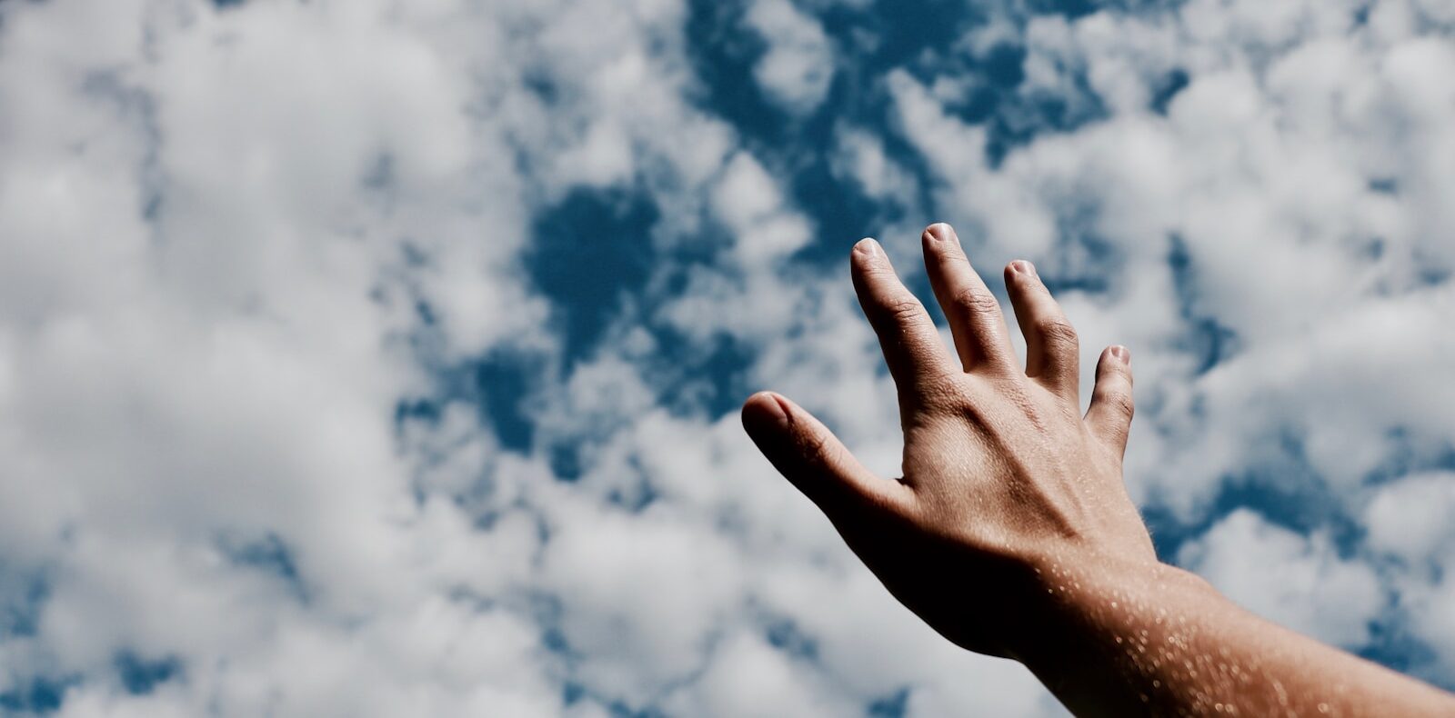 person hand reaching for the sky
