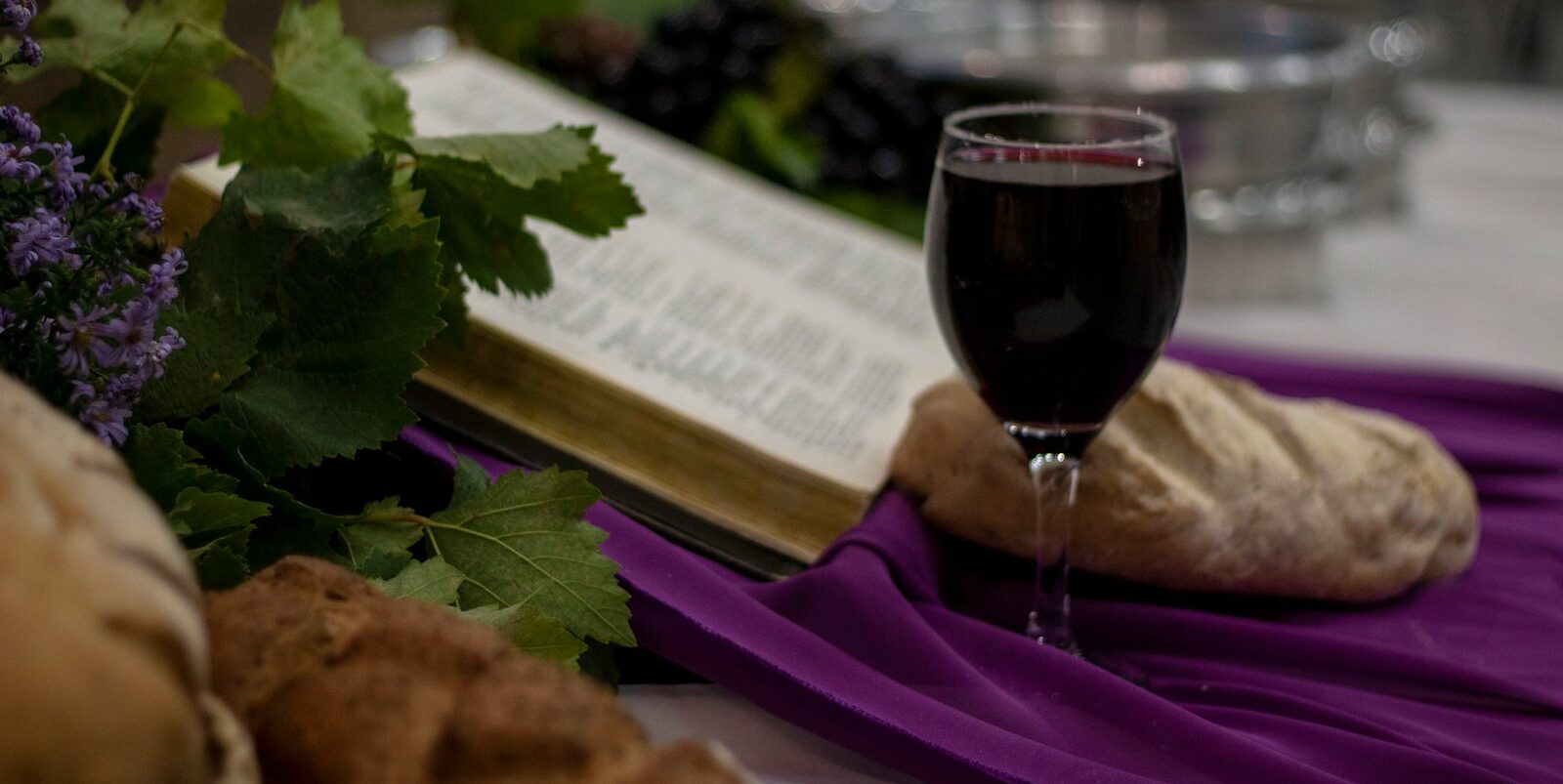 a glass of wine and a book on a table