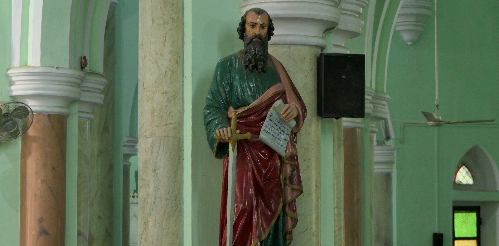 a statue of a man holding a book in a church