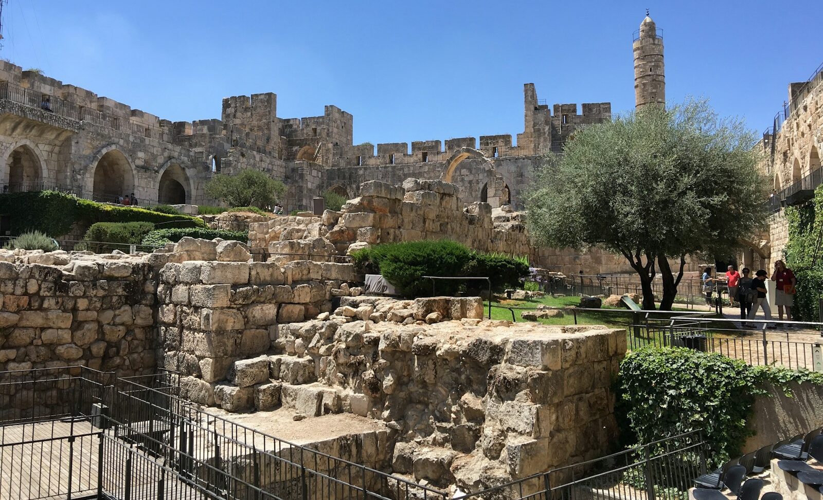 a group of people walking around a stone building