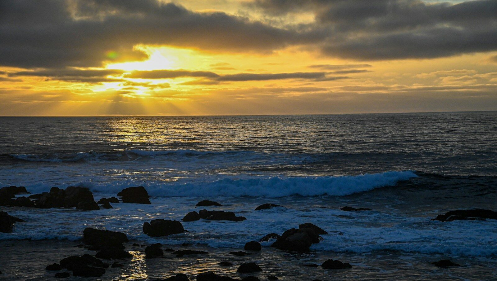 a rocky beach with a sunset