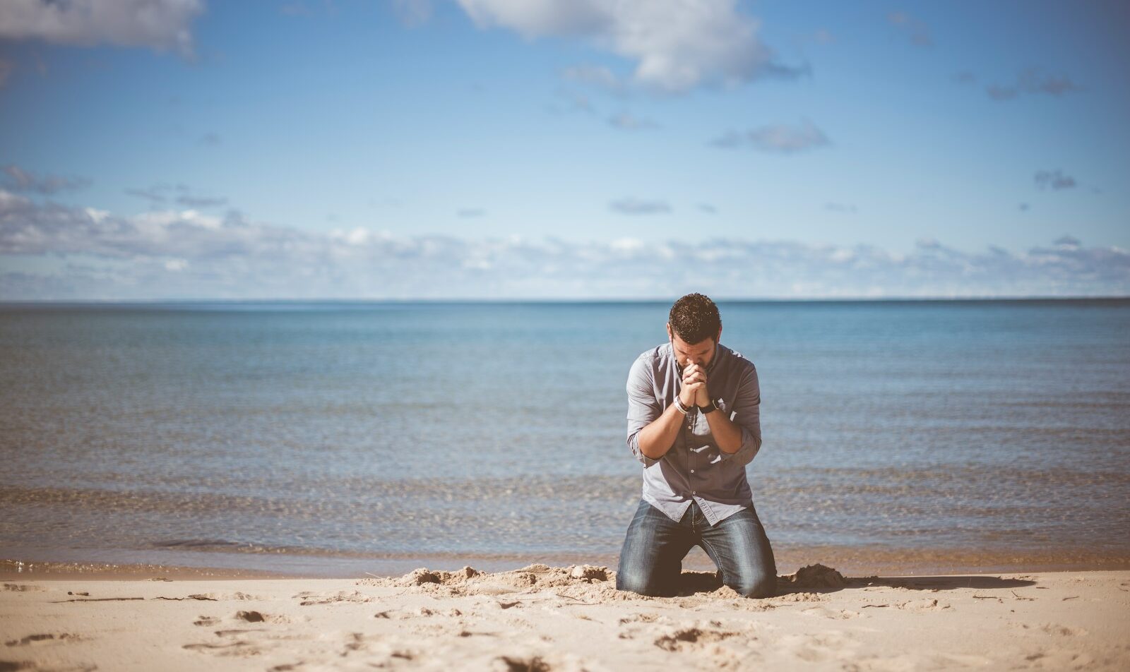 man kneeling down near shore