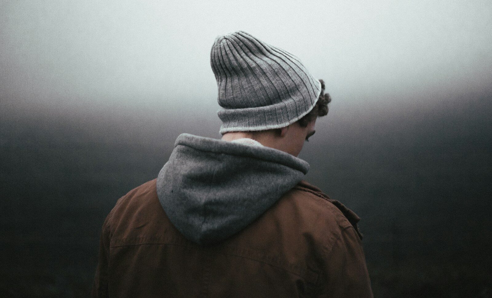 man wearing knit cap on grey background