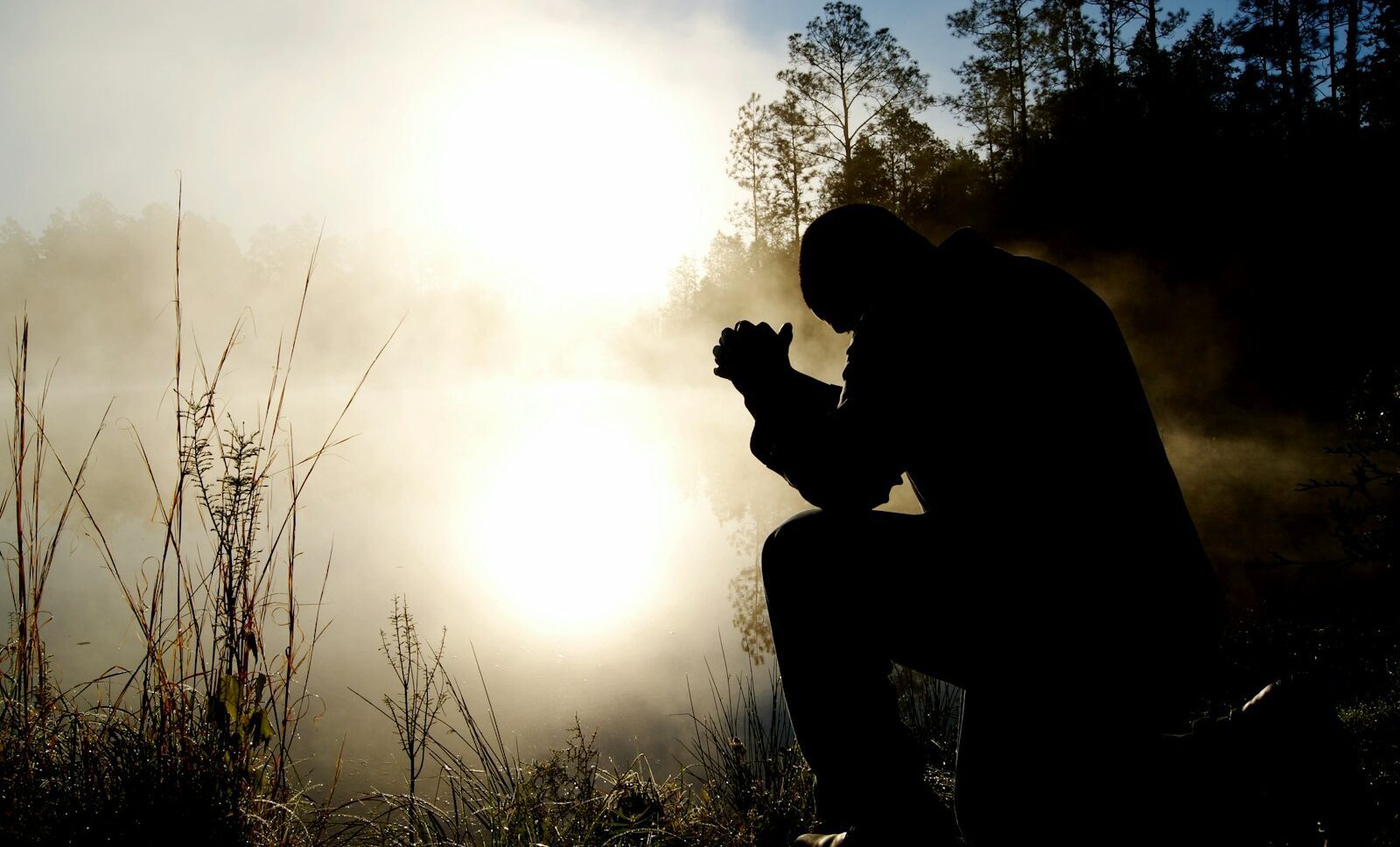 silhouette of kneeling man