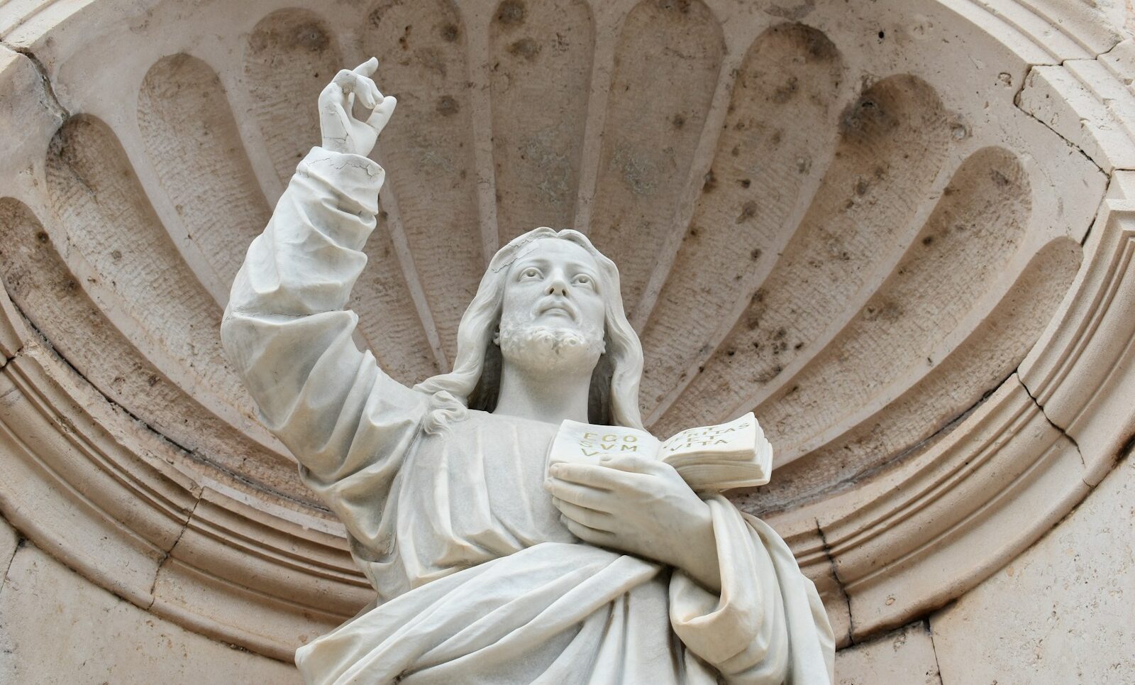 a statue of a person holding a book