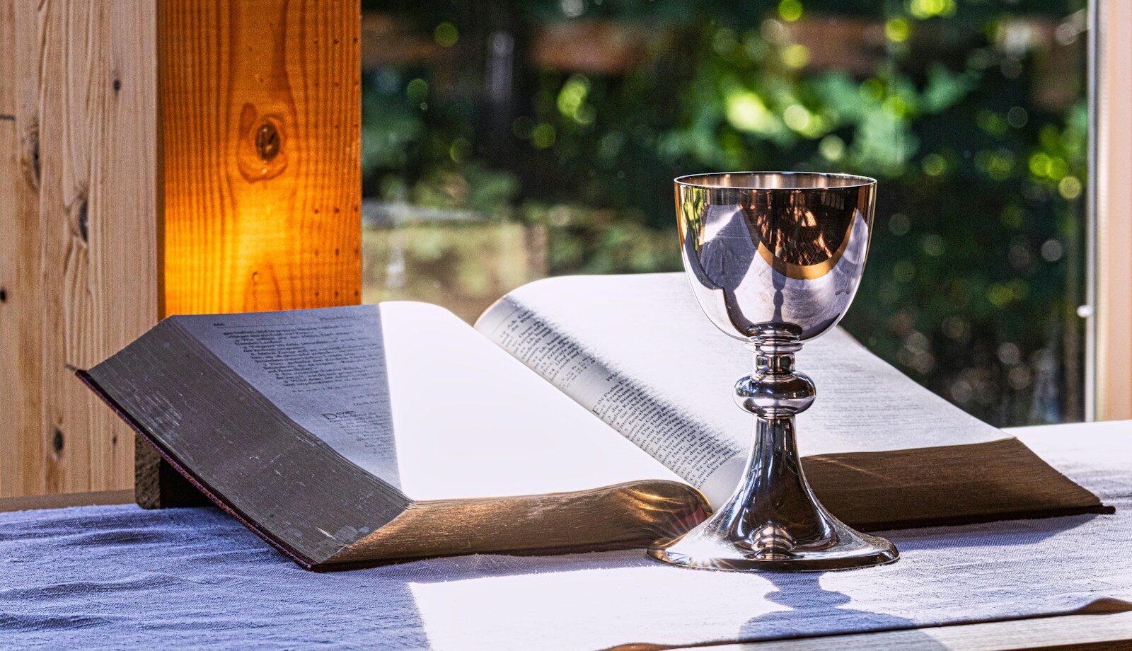 an open book and a chalice on a table