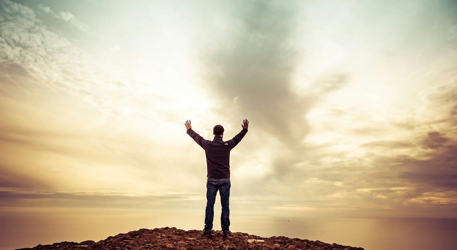 man standing under orange sky