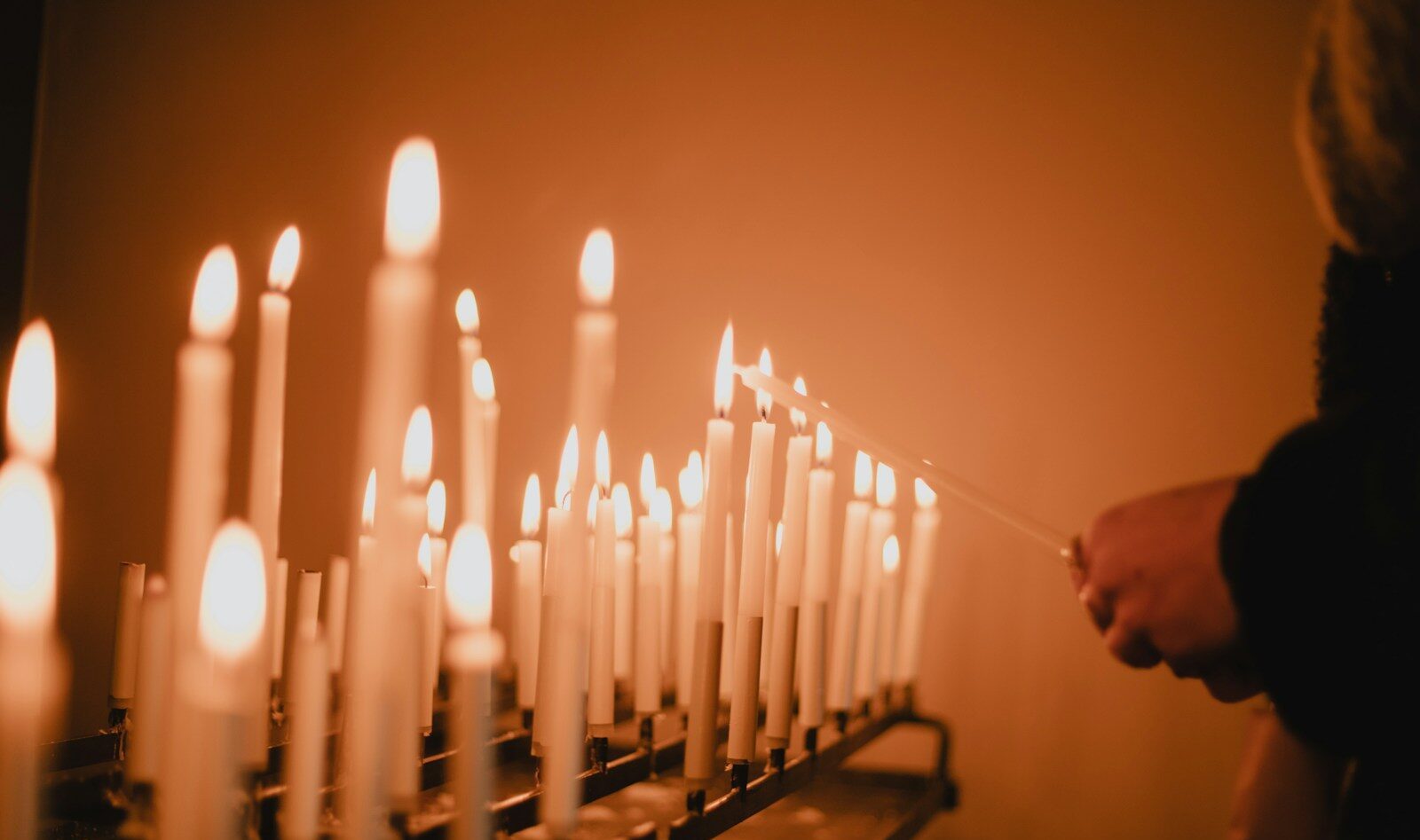 man standing near lighted candles