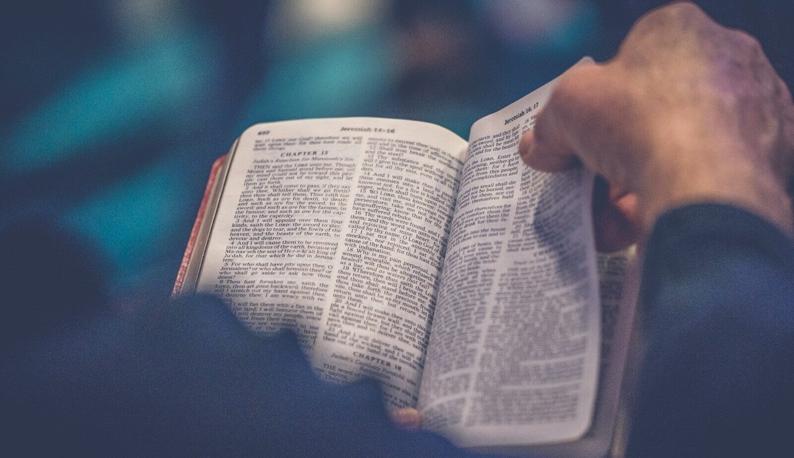 person's hand holding book page