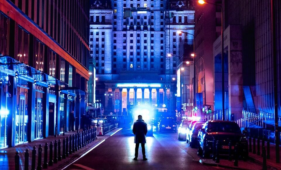 people walking on sidewalk near high rise buildings during night time