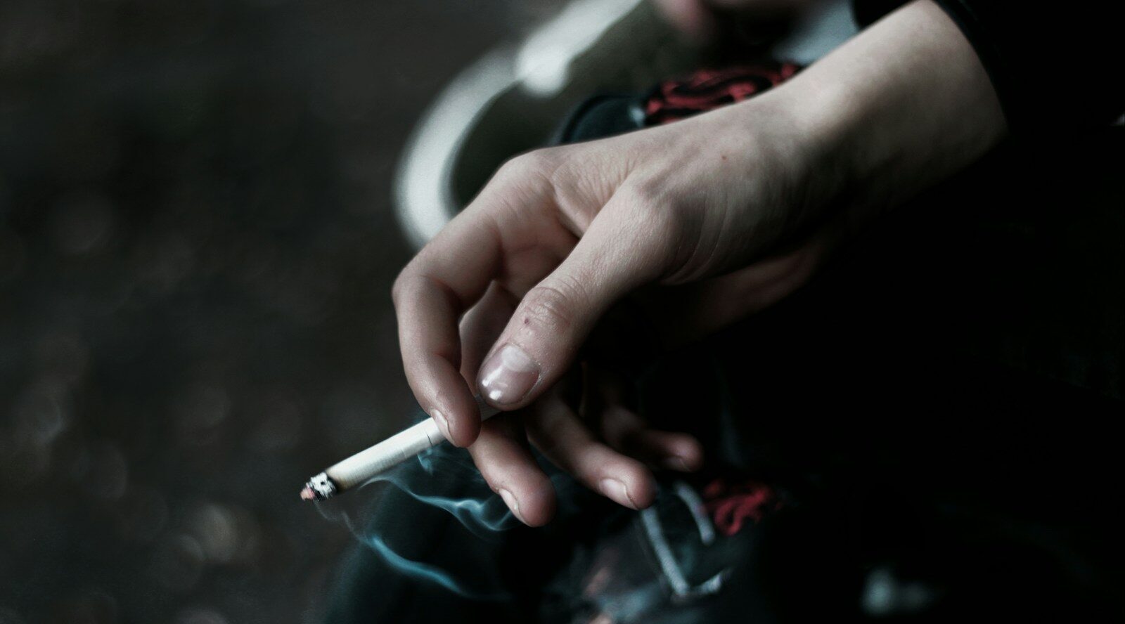 A person holding a cigarette in their hand