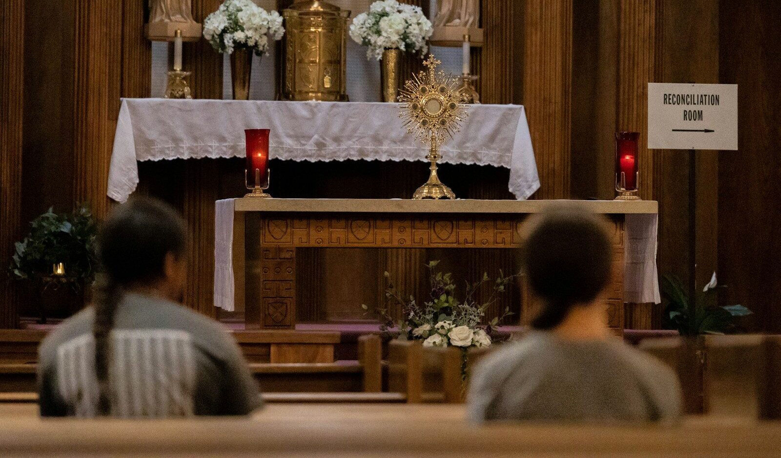 a couple of people sitting in front of a church alter