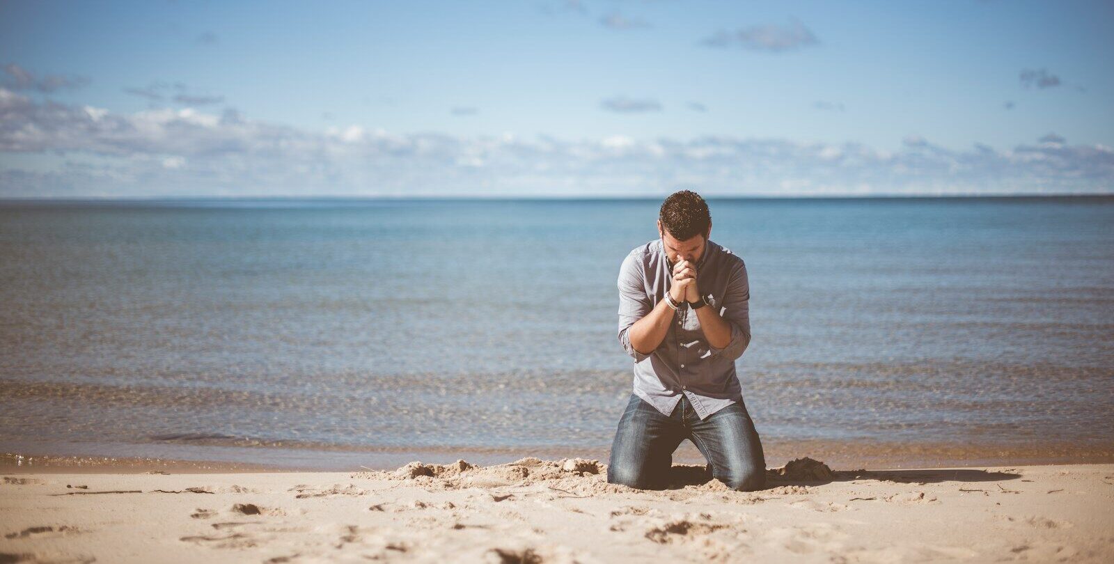 man kneeling down near shore