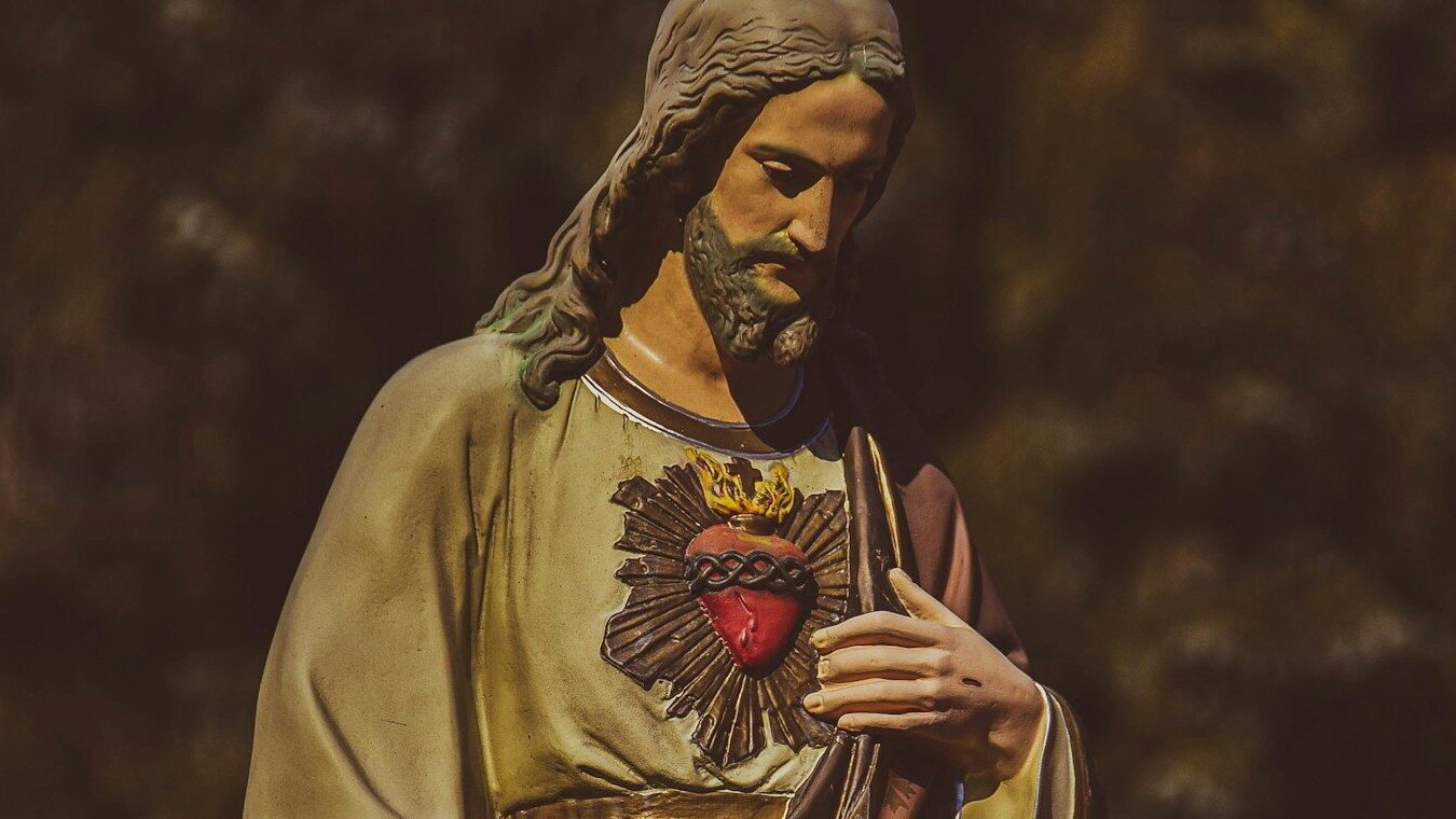 a statue of jesus holding his hands together