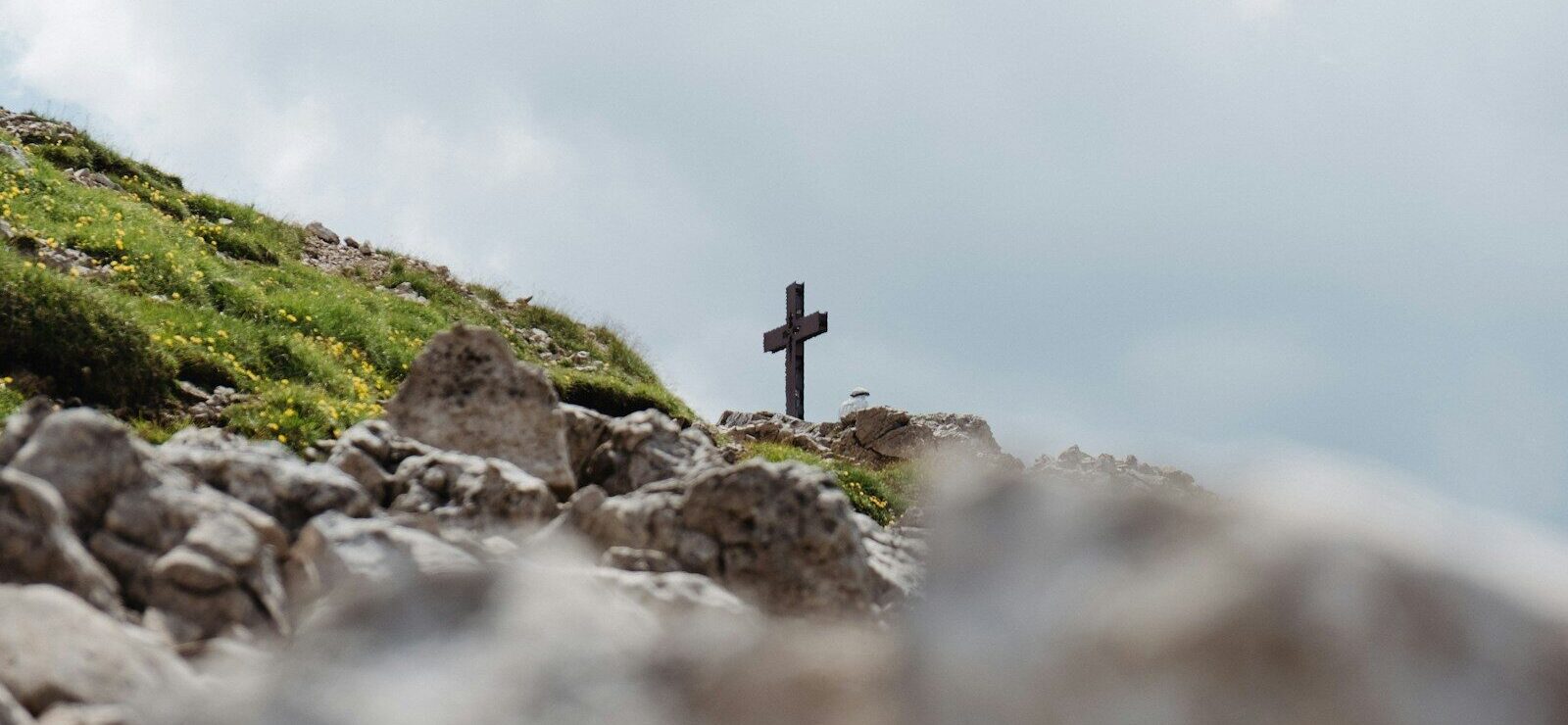 black cross on gray rocks under white sky during daytime