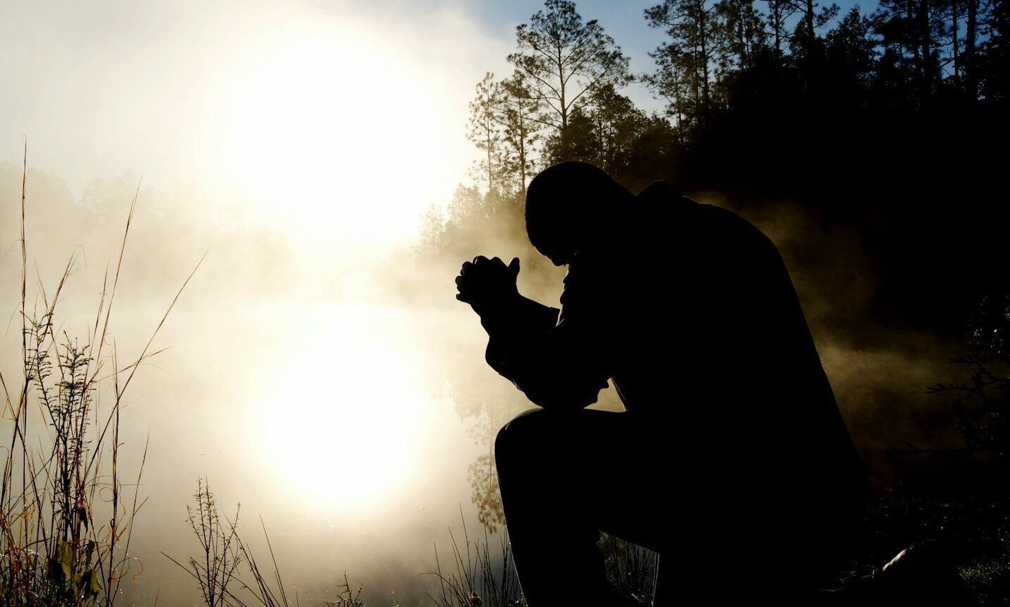 silhouette of kneeling man