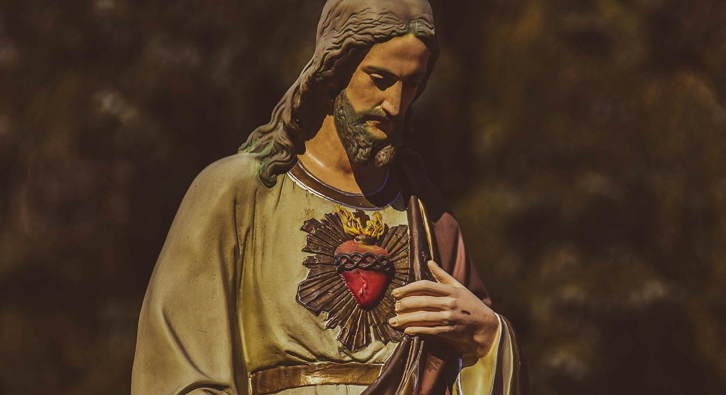 a statue of jesus holding his hands together