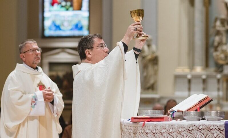 Priest holding chalice during religious ceremony