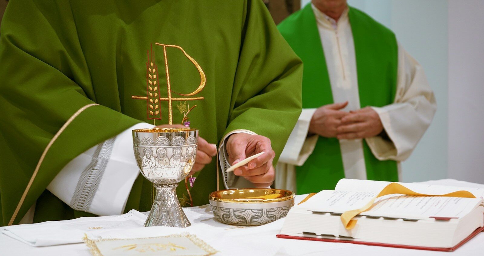 a priest is lighting a candle on a table