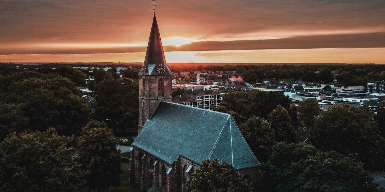 a church steeple with a sunset in the background