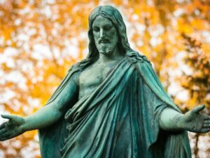 statue of a woman with a background of trees