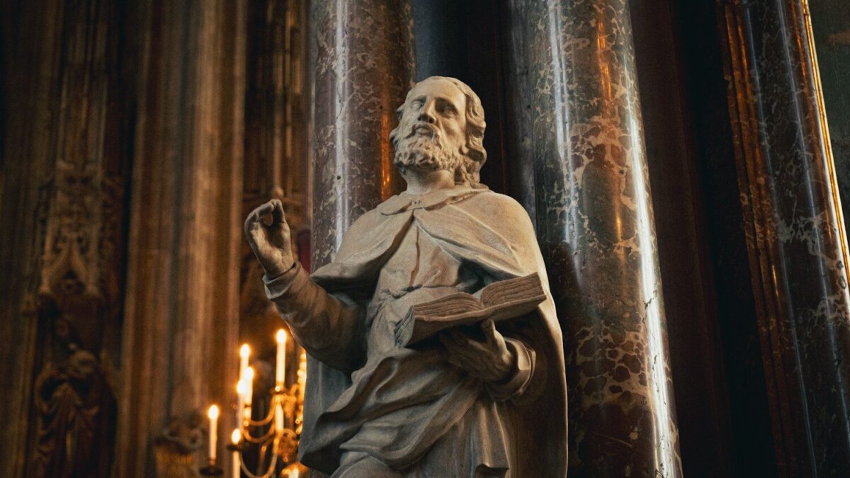 a statue of a man holding a book in a church
