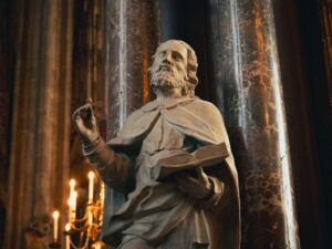 a statue of a man holding a book in a church