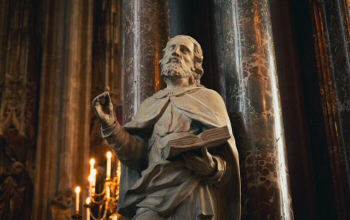 a statue of a man holding a book in a church