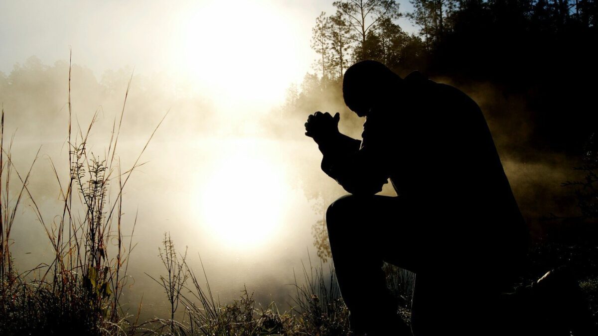 silhouette of kneeling man
