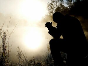 silhouette of kneeling man