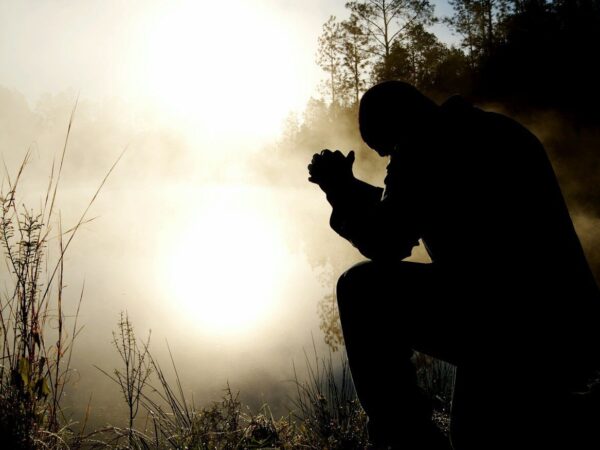 silhouette of kneeling man
