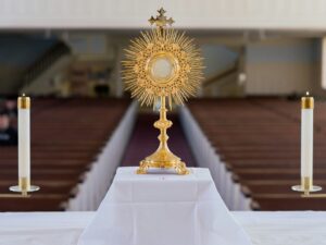 A golden monstrance with candles on an altar