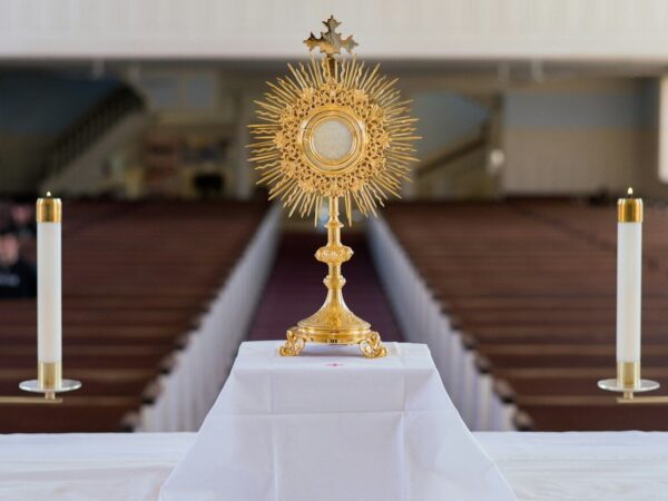 A golden monstrance with candles on an altar