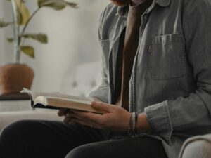 woman in blue denim jacket and black pants sitting on couch