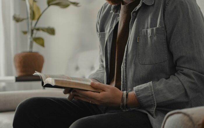 woman in blue denim jacket and black pants sitting on couch