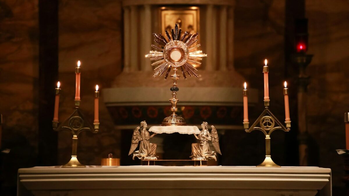 a church alter with candles and a clock on it