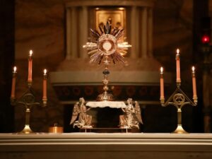 a church alter with candles and a clock on it